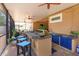 Covered outdoor kitchen featuring a built-in grill, bar seating, sink, and blue cabinets at 14830 Winkfield Ct, Winter Garden, FL 34787