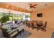 Enclosed patio featuring ample seating, dining table, ceiling fans, and serene backyard views at 14830 Winkfield Ct, Winter Garden, FL 34787