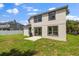 Exterior backyard view of home featuring ample grassy space, patio and large sliding glass doors at 14927 Faversham Cir, Orlando, FL 32826