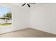 Bright bedroom with a ceiling fan and large window overlooking the backyard at 14927 Faversham Cir, Orlando, FL 32826