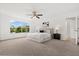 Bright bedroom with a large window, ceiling fan, and carpet floors, offering a comfortable and relaxing space at 14927 Faversham Cir, Orlando, FL 32826