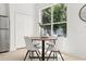 Bright dining area with a wooden table, four chairs, and large windows, offering a cozy space at 14927 Faversham Cir, Orlando, FL 32826