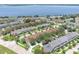 Aerial view of townhouses near a lake with lush, landscaped surroundings at 152 Riggings Way, Clermont, FL 34711