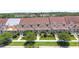 Aerial view of townhomes featuring well-manicured lawns, mature trees, and newer roofs at 152 Riggings Way, Clermont, FL 34711