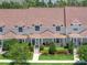 Aerial view of townhomes with well-maintained lawns and inviting front porches at 152 Riggings Way, Clermont, FL 34711