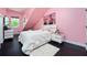 Bright pink bedroom with a plush white bed, modern furniture, and a large window at 152 Riggings Way, Clermont, FL 34711