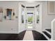 Bright entryway with hardwood floors, side windows, stairway access, and wall art creates an inviting welcome at 152 Riggings Way, Clermont, FL 34711