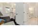Hallway view showing a bedroom with dark floors and a bathroom with white tile, connecting living spaces seamlessly at 152 Riggings Way, Clermont, FL 34711
