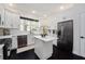 Bright kitchen features white cabinetry, stainless steel appliances, quartz countertops, and a kitchen island at 152 Riggings Way, Clermont, FL 34711