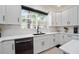 A well-lit kitchen features black hardware, quartz countertops, stainless steel dishwasher, and a large window at 152 Riggings Way, Clermont, FL 34711