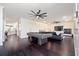 Expansive living room boasts hardwood floors, recessed lighting, a large ceiling fan, and a stylish pool table at 152 Riggings Way, Clermont, FL 34711
