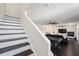 View from staircase to downstairs living room with pool table, TV and black hardwood floors at 152 Riggings Way, Clermont, FL 34711