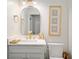 Elegant powder room with gold fixtures, a white vanity, and stylish decor at 152 Riggings Way, Clermont, FL 34711