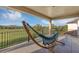 Spacious covered balcony featuring hammock, iron railing with relaxing views of a green lawn and blue sky at 15769 Shorebird Ln, Winter Garden, FL 34787