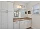 Bathroom featuring a white vanity with a large mirror and cabinetry, plus overhead lighting and a window at 15769 Shorebird Ln, Winter Garden, FL 34787
