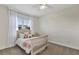 Cozy bedroom featuring carpeted floors, a ceiling fan, and a charming bed with decorative pillows and a plush, pink throw at 15769 Shorebird Ln, Winter Garden, FL 34787