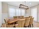 Dining area features a live edge table, seating for eight, modern light fixture, and curtains at 15769 Shorebird Ln, Winter Garden, FL 34787