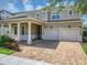 Charming two-story home with a two-car garage, brick paver driveway, and covered entry with columns at 15769 Shorebird Ln, Winter Garden, FL 34787