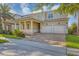 Elegant two-story home with a brick paver driveway, covered entryway, and a two-car garage at 15769 Shorebird Ln, Winter Garden, FL 34787