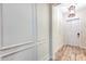 Hallway featuring elegant wall paneling, wood-look flooring, and a modern light fixture above a white door at 15769 Shorebird Ln, Winter Garden, FL 34787