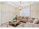 Bright living room features a decorative chandelier, neutral furniture, and elegant window treatments at 15769 Shorebird Ln, Winter Garden, FL 34787