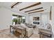 Bright living room features a stone fireplace, wood beams, and sliding glass doors at 15769 Shorebird Ln, Winter Garden, FL 34787
