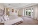 Spacious main bedroom featuring carpeted floors, a balcony view, and natural light from three windows at 15769 Shorebird Ln, Winter Garden, FL 34787