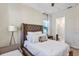Bright main bedroom featuring carpet, a cushioned headboard, and a view into the bathroom, also with a crib at 15769 Shorebird Ln, Winter Garden, FL 34787