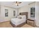 Comfortable main bedroom featuring carpet, a ceiling fan, bedside table, and large windows dressed with white drapes at 15769 Shorebird Ln, Winter Garden, FL 34787