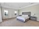 Bright main bedroom featuring carpeted floors, a large bed, and natural light from two windows at 15769 Shorebird Ln, Winter Garden, FL 34787