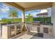 Luxurious outdoor kitchen with stainless steel appliances and a covered patio area at 15769 Shorebird Ln, Winter Garden, FL 34787