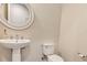 Bright powder room with pedestal sink, round mirror, and toilet at 15769 Shorebird Ln, Winter Garden, FL 34787