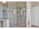 Glass shower with tile surround featuring decorative accent strip and open door leading to toilet and storage at 15769 Shorebird Ln, Winter Garden, FL 34787