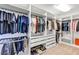 Large walk-in closet with custom shelving, ample hanging space, and organized storage solutions at 15769 Shorebird Ln, Winter Garden, FL 34787