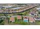 Wide aerial showing residential neighborhood with tile roofs, pools, lake, and lush landscaping at 1640 Oak Blossom Dr, Davenport, FL 33837