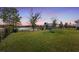 A sprawling backyard boasts a play set, providing ample space for recreation, with scenic views of the adjacent pond at 1640 Oak Blossom Dr, Davenport, FL 33837
