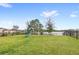 Large, green backyard with a swing set, slide, and views of a serene lake beyond a black metal fence at 1640 Oak Blossom Dr, Davenport, FL 33837