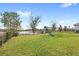 Spacious backyard with a swing set, slide, and lake view, enclosed by a black metal fence for added security at 1640 Oak Blossom Dr, Davenport, FL 33837