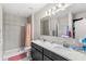 Bathroom featuring a double sink vanity, shower, and a large mirror at 1640 Oak Blossom Dr, Davenport, FL 33837