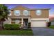 Inviting two-story home featuring a well-manicured lawn and beautiful landscaping at 1640 Oak Blossom Dr, Davenport, FL 33837