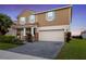 Charming two-story home with a paved driveway and well-maintained landscaping at 1640 Oak Blossom Dr, Davenport, FL 33837
