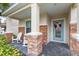 Inviting front porch with brick accents, rocking chairs, and a charming light blue door with decorative wreath at 1640 Oak Blossom Dr, Davenport, FL 33837