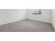 Bright bedroom with neutral carpet, white walls, and a window providing natural light at 2089 Rosewood Dr, Bartow, FL 33830