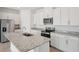 Well-equipped kitchen featuring granite countertops, sleek stainless steel appliances, and white cabinets at 2089 Rosewood Dr, Bartow, FL 33830