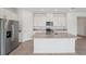 Modern kitchen featuring white cabinets, granite countertops, stainless steel appliances, and a large center island at 2089 Rosewood Dr, Bartow, FL 33830