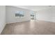Bright living room featuring tile floors, white walls, and natural light from a sliding glass door and large window at 2089 Rosewood Dr, Bartow, FL 33830