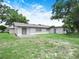 A spacious backyard showcases the home's exterior, highlighting a concrete patio perfect for outdoor relaxation at 228 Kilmer Ln, Winter Haven, FL 33884