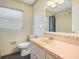 Bathroom featuring tiled walls, a toilet, and vanity with a bright pink countertop at 228 Kilmer Ln, Winter Haven, FL 33884