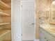 Bathroom with open shelving, single sink vanity, and patterned wallpaper at 228 Kilmer Ln, Winter Haven, FL 33884