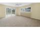 Bedroom featuring neutral carpet, large window, and sliding glass door to the patio at 228 Kilmer Ln, Winter Haven, FL 33884